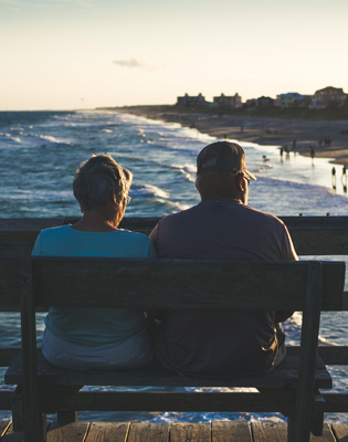 Image to represent an older couple enjoying their pension and benefits by sitting on a bench